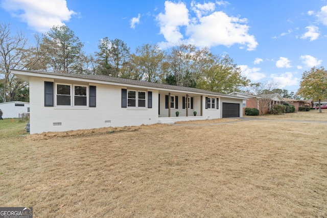 ranch-style home featuring covered porch and a garage