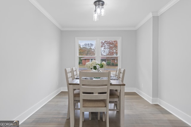 dining space with hardwood / wood-style floors and crown molding