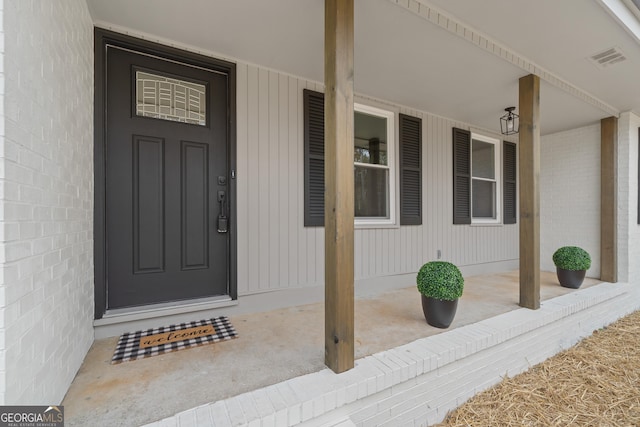 view of exterior entry featuring covered porch