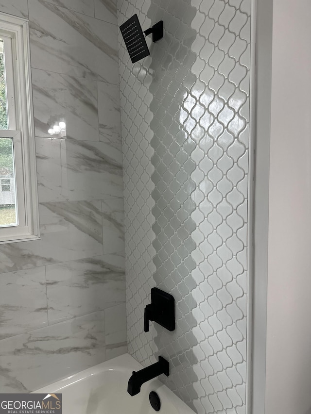 bathroom featuring tiled shower / bath combo and a healthy amount of sunlight