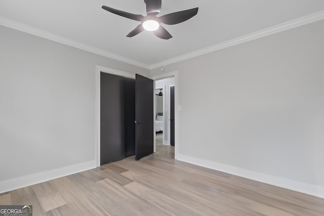 unfurnished room featuring ceiling fan, light wood-type flooring, and ornamental molding