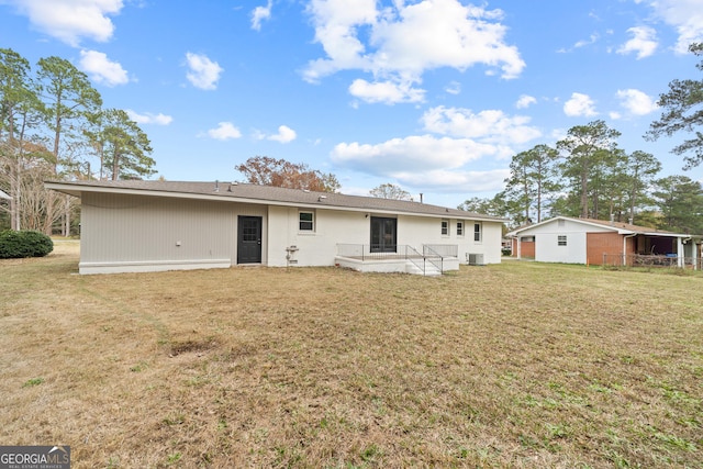 back of house featuring a lawn and central AC