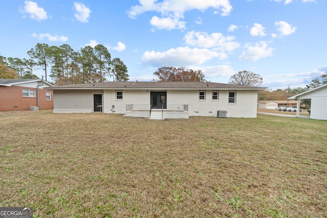 rear view of property featuring cooling unit and a lawn