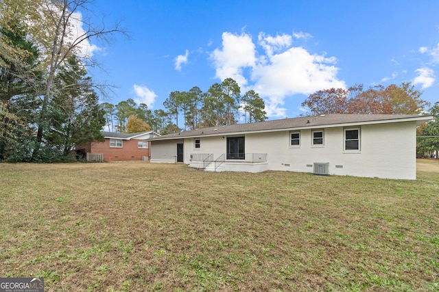 back of property featuring a yard and central air condition unit