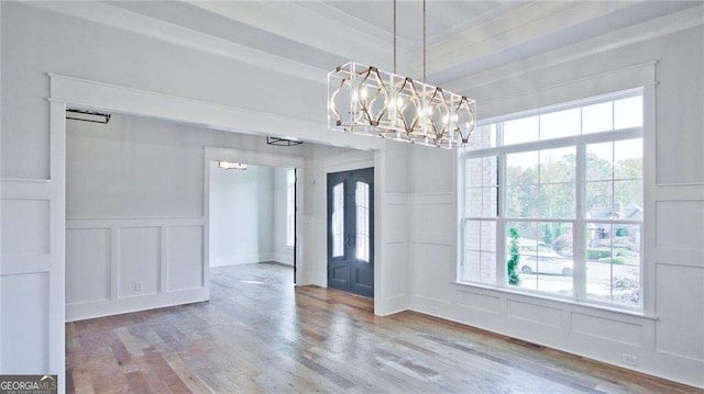 entryway with hardwood / wood-style flooring, an inviting chandelier, and a wealth of natural light