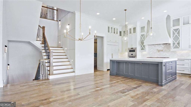 kitchen with premium range hood, a spacious island, pendant lighting, gray cabinets, and white cabinetry