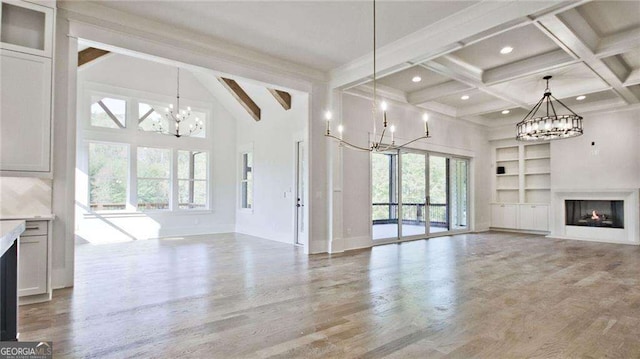 unfurnished living room featuring beam ceiling, a healthy amount of sunlight, and hardwood / wood-style flooring