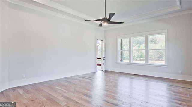 unfurnished room featuring a tray ceiling, ornamental molding, and hardwood / wood-style flooring