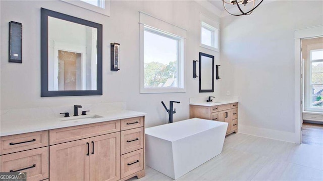 bathroom featuring vanity, a healthy amount of sunlight, and a chandelier