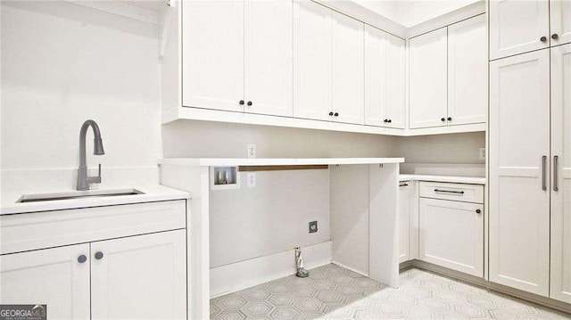 washroom with cabinets, hookup for a washing machine, and sink