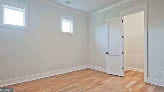 unfurnished room featuring light hardwood / wood-style flooring and crown molding