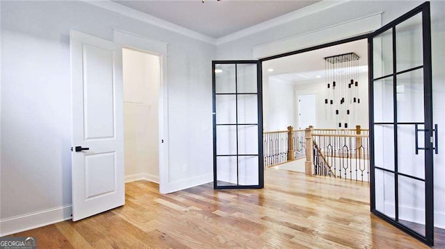 unfurnished room featuring ornamental molding and light hardwood / wood-style flooring