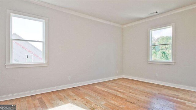 unfurnished room with light hardwood / wood-style floors and ornamental molding