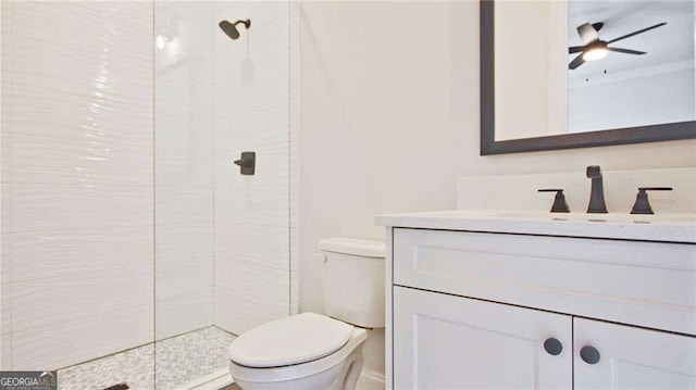 bathroom featuring vanity, ceiling fan, toilet, and a tile shower