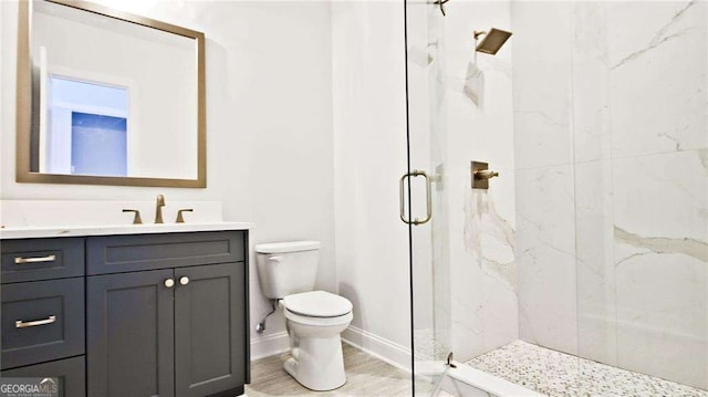 bathroom featuring vanity, hardwood / wood-style flooring, toilet, and a shower with shower door