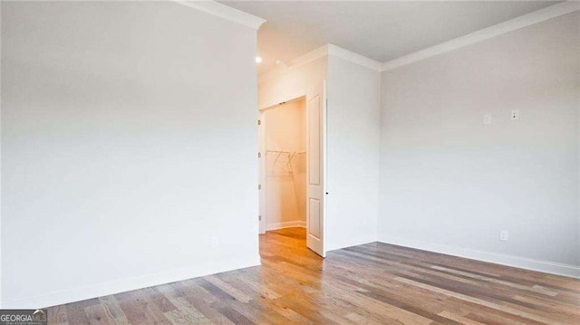 unfurnished room with hardwood / wood-style flooring and crown molding