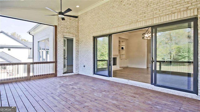 unfurnished sunroom with ceiling fan with notable chandelier