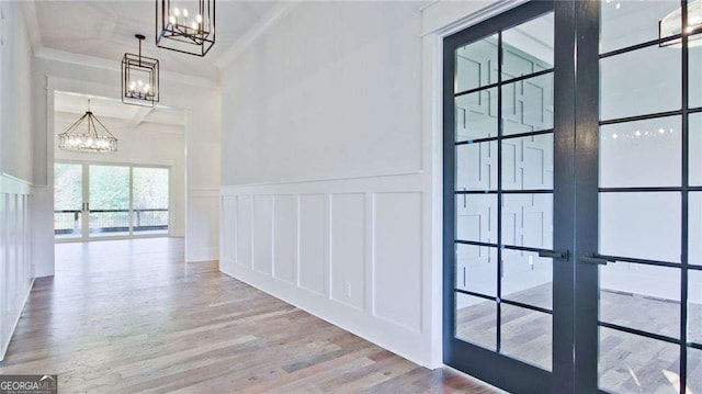 corridor featuring french doors, hardwood / wood-style flooring, and crown molding