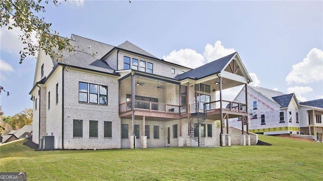 rear view of property with a balcony, central AC, ceiling fan, and a lawn