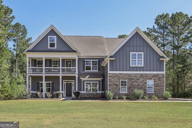 craftsman inspired home featuring a balcony and a front yard