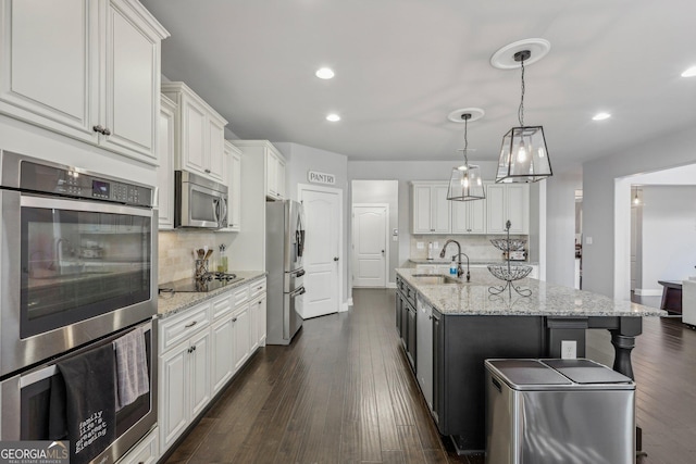 kitchen with sink, white cabinetry, dark wood-type flooring, and appliances with stainless steel finishes