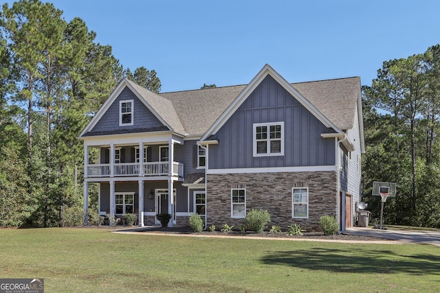 view of front of home with a garage, a balcony, and a front yard