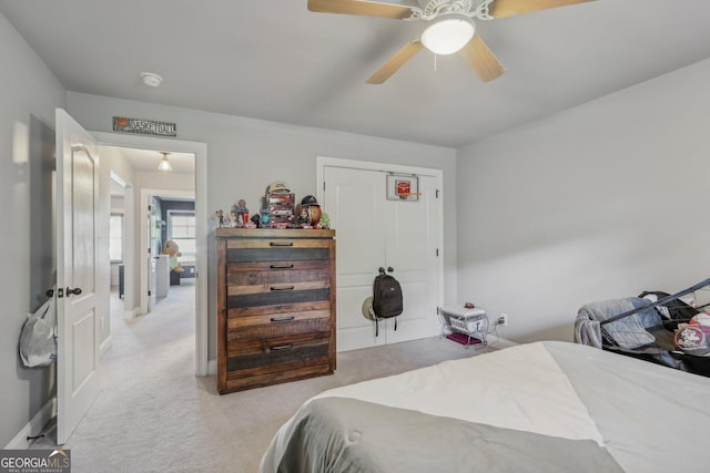 carpeted bedroom featuring ceiling fan and a closet