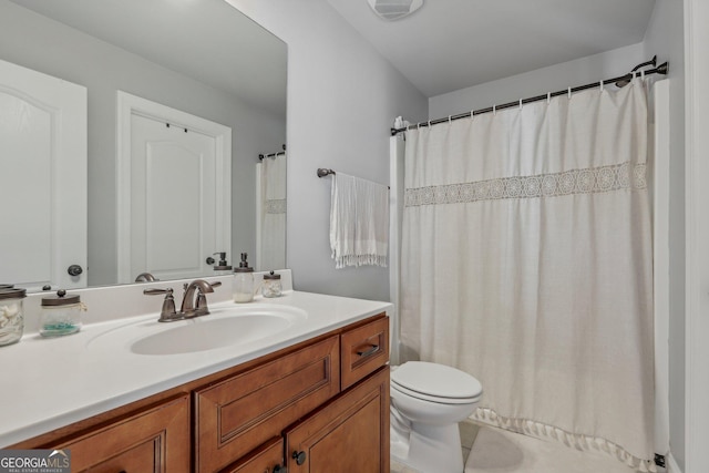 bathroom with tile patterned flooring, vanity, and toilet