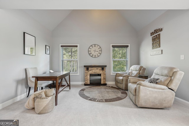 interior space with carpet floors, high vaulted ceiling, and a stone fireplace