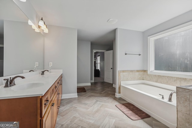 bathroom with parquet flooring, vanity, and a tub