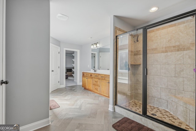 bathroom featuring vanity, a shower with shower door, and parquet flooring