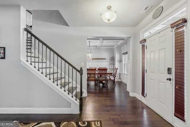 foyer featuring beamed ceiling, dark wood-type flooring, and coffered ceiling