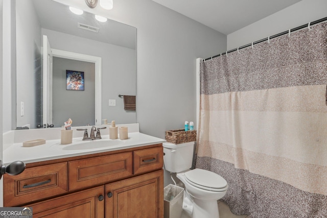 bathroom featuring walk in shower, vanity, and toilet