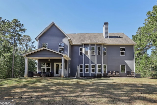 back of house featuring central AC unit, ceiling fan, and a lawn