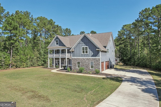 view of front of house featuring a garage, a balcony, and a front yard