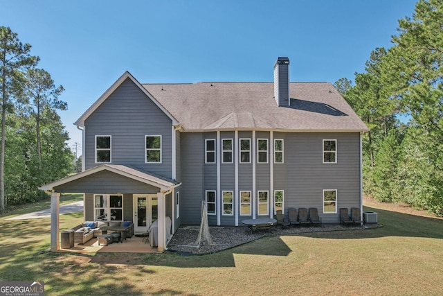 back of property with a lawn, an outdoor living space, cooling unit, and a patio