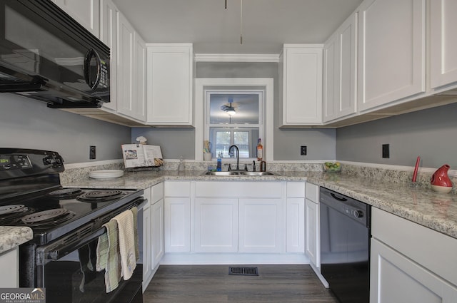 kitchen with dark wood-type flooring, black appliances, white cabinets, sink, and ornamental molding