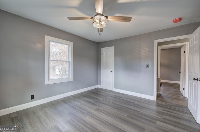 unfurnished bedroom with ceiling fan, a closet, and wood-type flooring