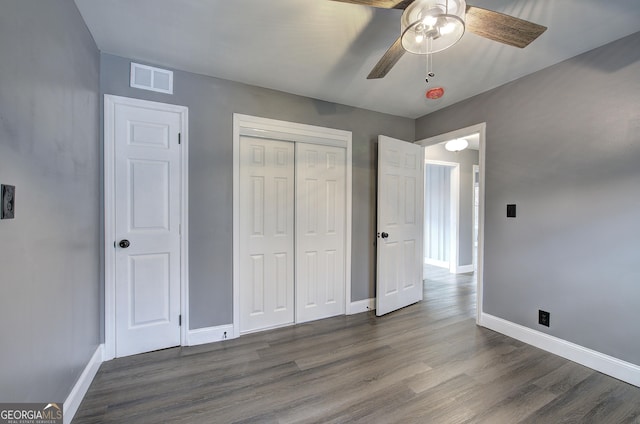 unfurnished bedroom featuring ceiling fan and dark wood-type flooring