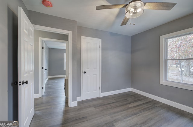 unfurnished bedroom featuring ceiling fan and dark hardwood / wood-style flooring