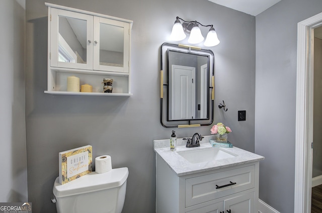 bathroom featuring vanity, hardwood / wood-style flooring, and toilet