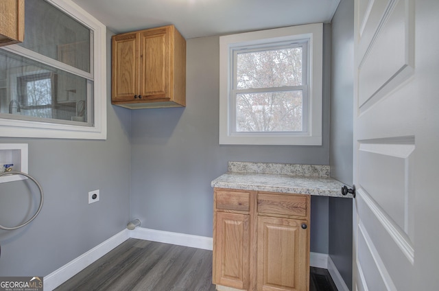 laundry area featuring cabinets, washer hookup, electric dryer hookup, and dark wood-type flooring