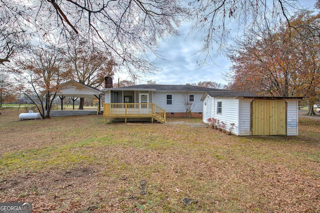 back of property featuring a lawn, a storage unit, and a deck