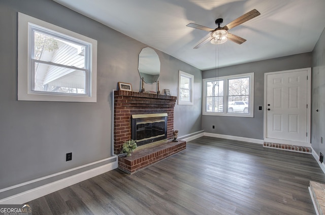 living room featuring ceiling fan, dark wood-type flooring, and a brick fireplace