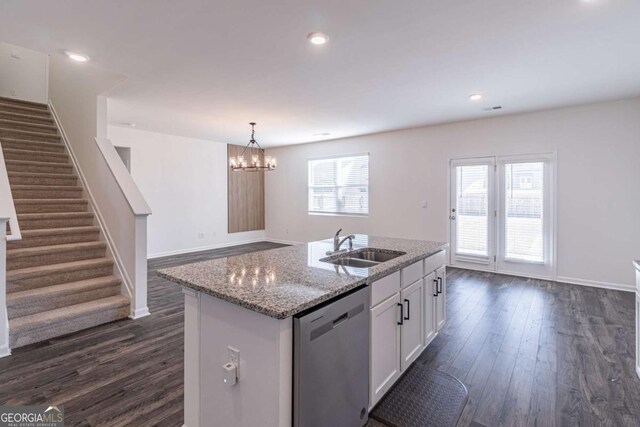 kitchen with dark wood-type flooring, light stone counters, stainless steel dishwasher, a kitchen island with sink, and white cabinets