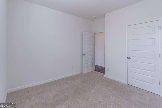 unfurnished bedroom featuring a closet and light colored carpet