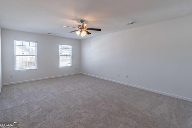 carpeted spare room with ceiling fan