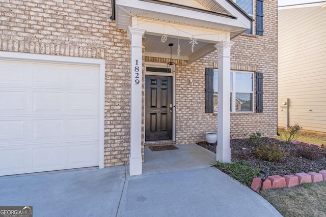 view of exterior entry with covered porch and a garage