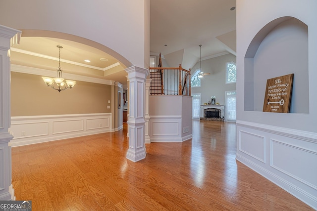 foyer entrance featuring hardwood / wood-style floors, ceiling fan with notable chandelier, and ornamental molding