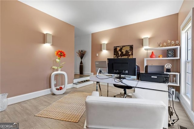 home office with light hardwood / wood-style flooring and a wealth of natural light